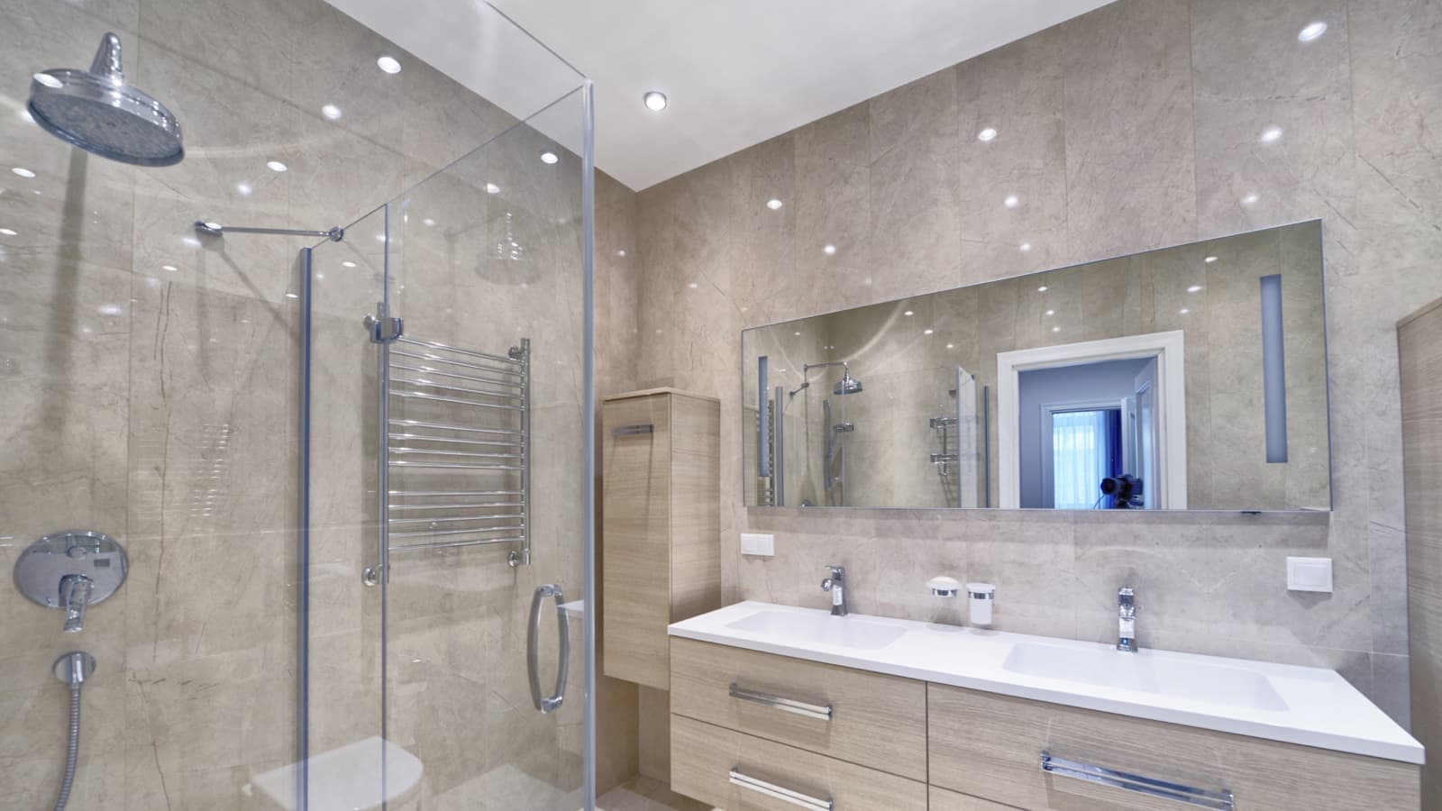 Modern ensuite with marble-look tiling, a glass corner shower, chrome heated towel rail and a timber double vanity