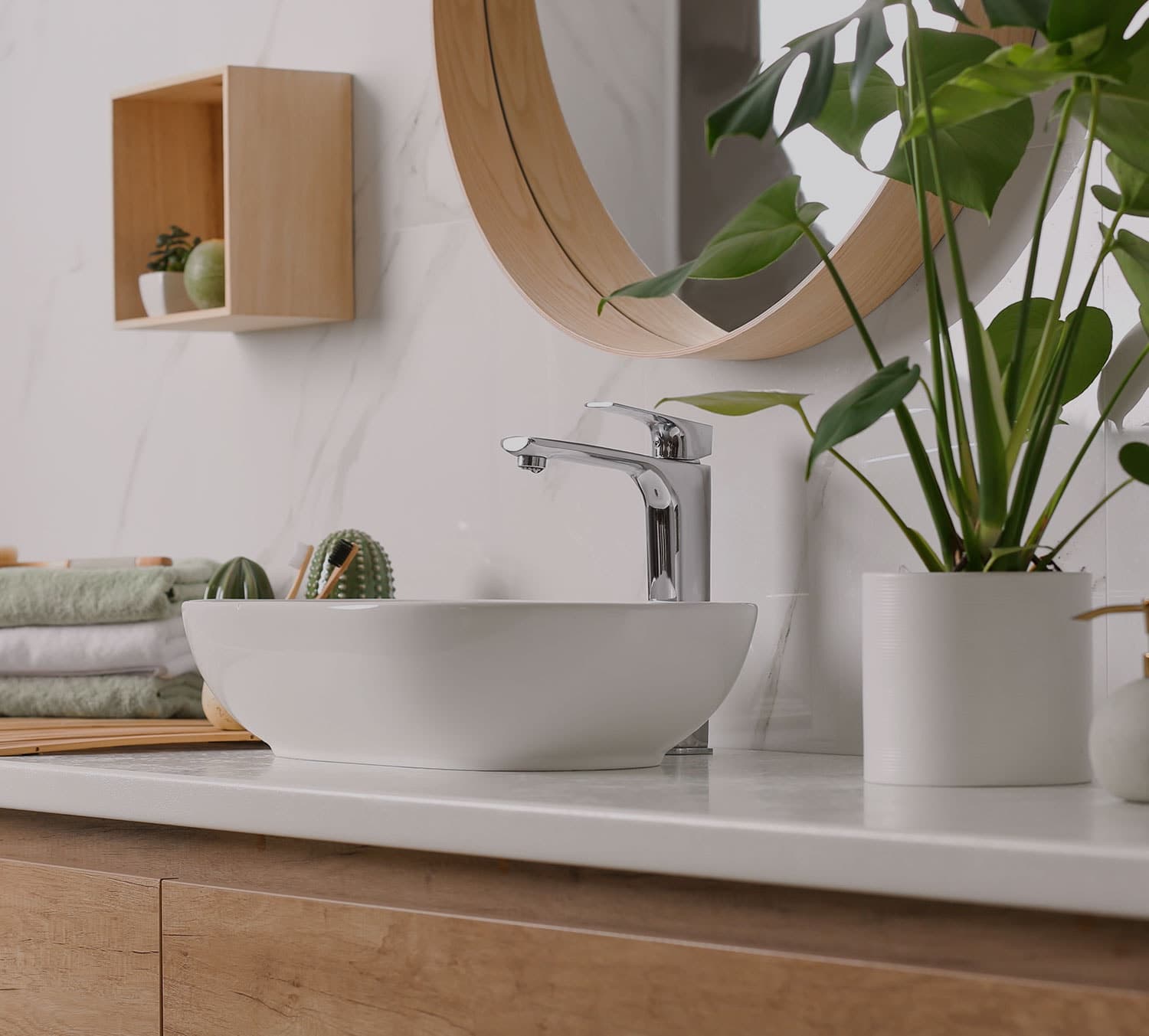 Countertop basin on a timber vanity with a round mirror above it